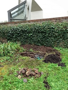 2. Bob and Tom mark out the base and start digging. We leave the hole covered in branches as the rain pours down