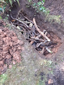 6. Filling the hole with layers of stone and branches